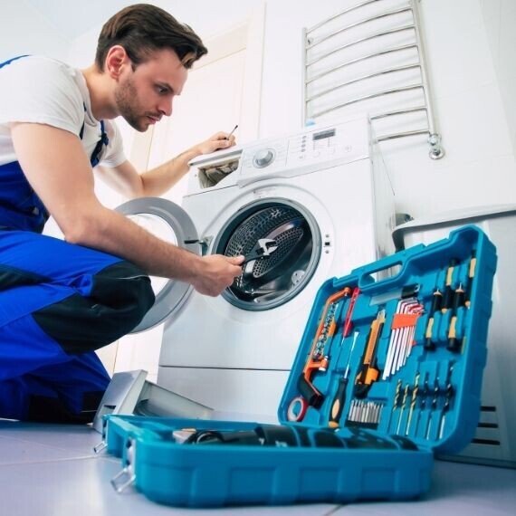 Çamaşır makinesinde teknik kontrol yapan servis teknisyeni